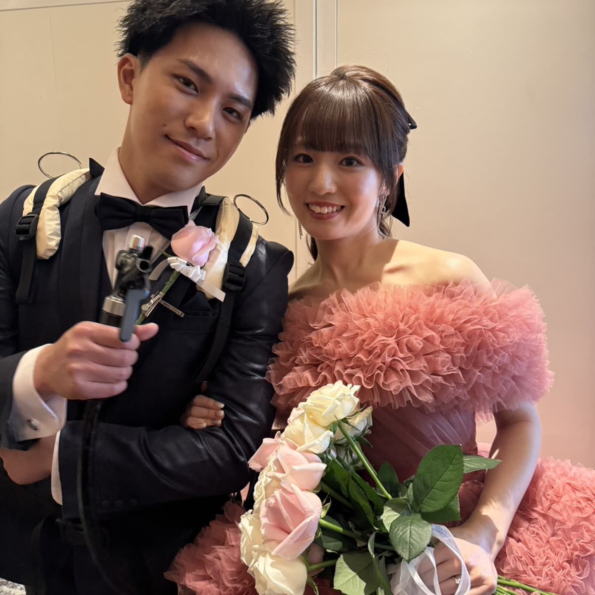 Couple at their wedding reception holding a bouquet, filmed by CJC