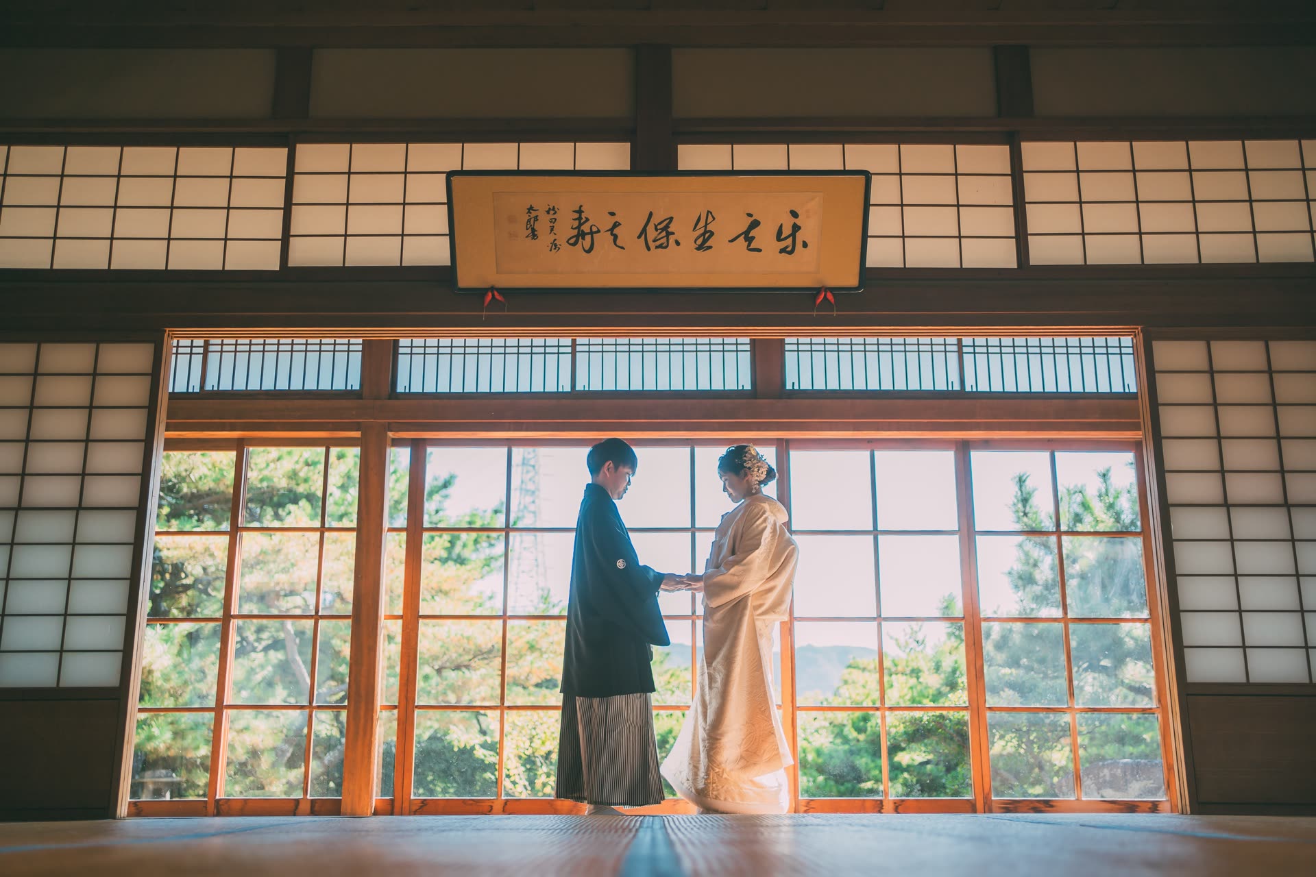Couple in kimono facing each other in a tatami room framed by shoji screens during a pre-wedding photoshoot in Japan