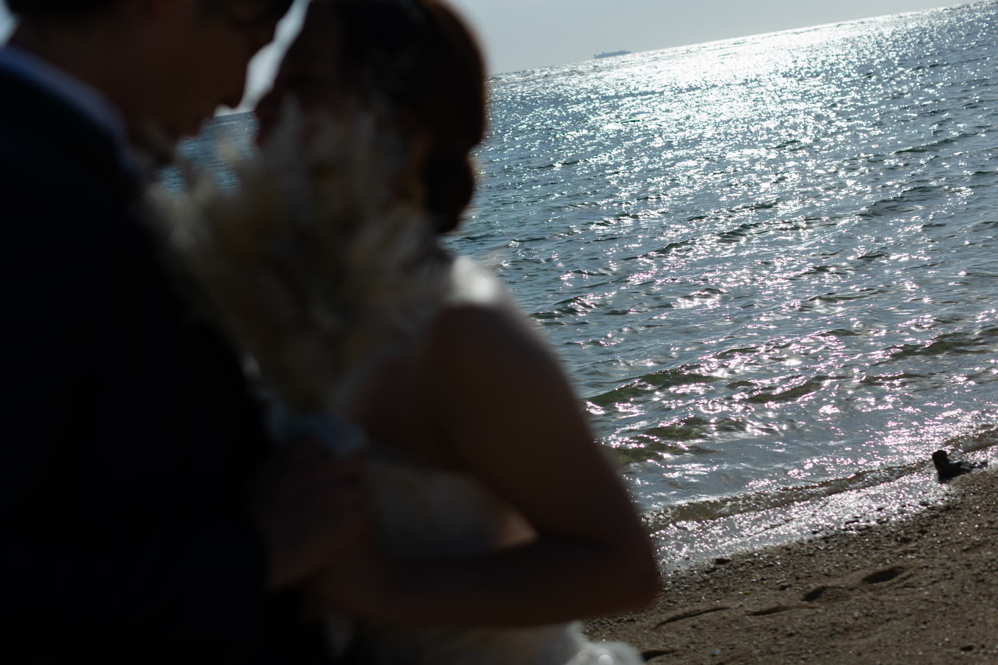 Bouquet held against sunlight sparkling on the Okinawa sea