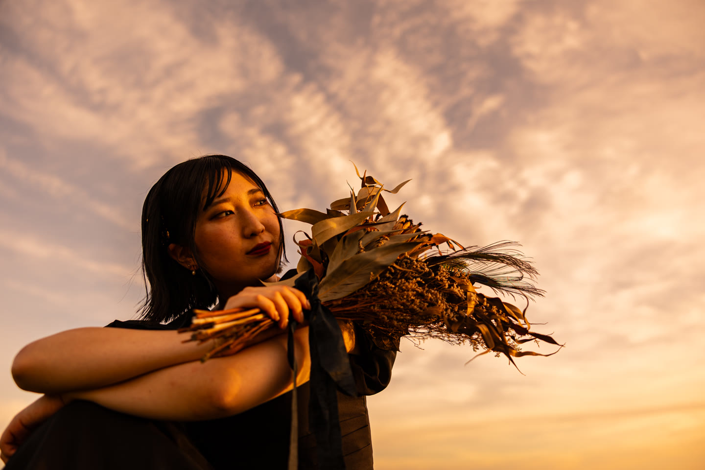 Bride smiling with her bouquet in golden hour light in Okinawa