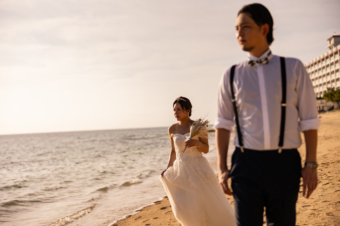 Bride walking the shoreline in the last of the evening light