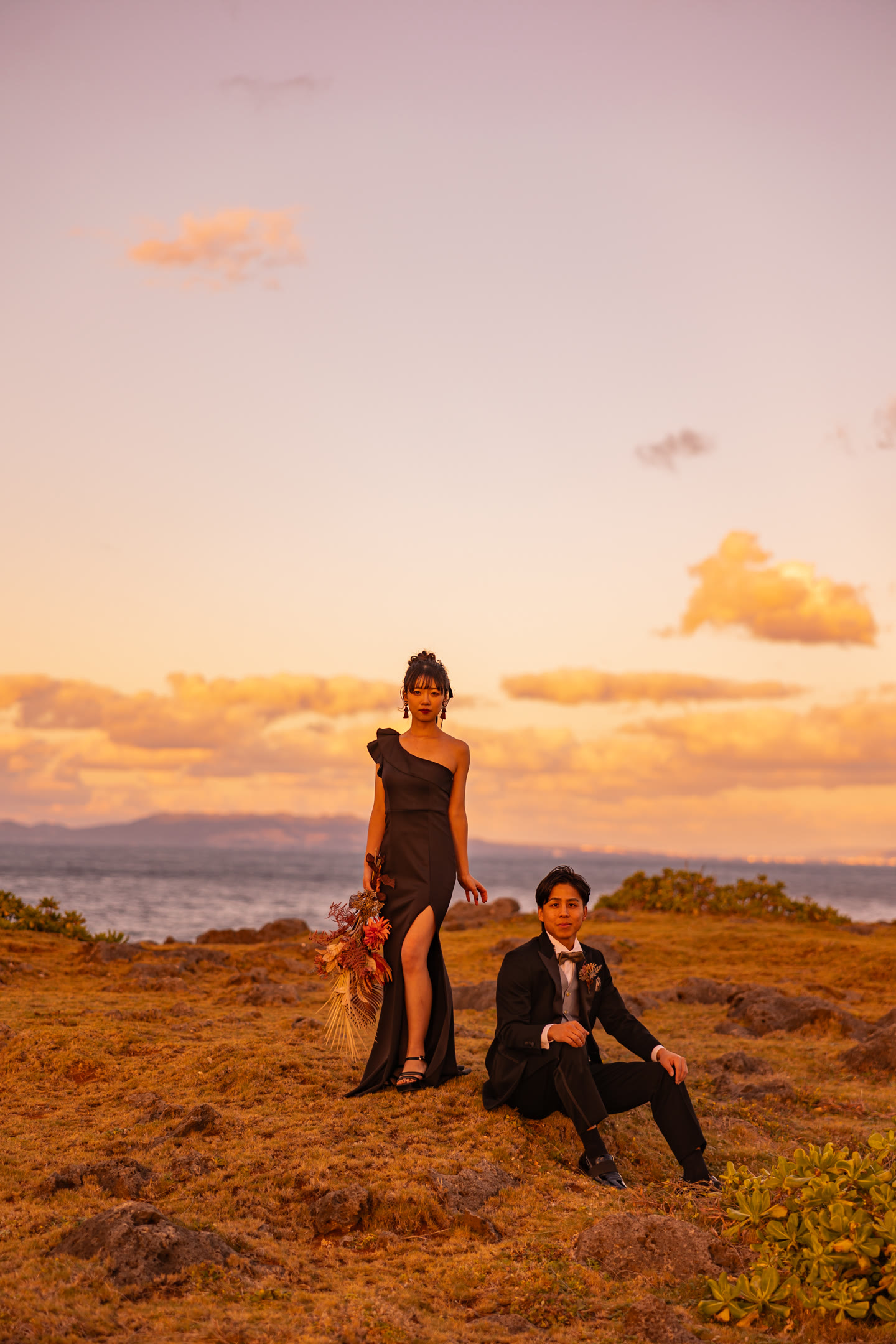 Couple on a cliff top against a sunset sky in Okinawa