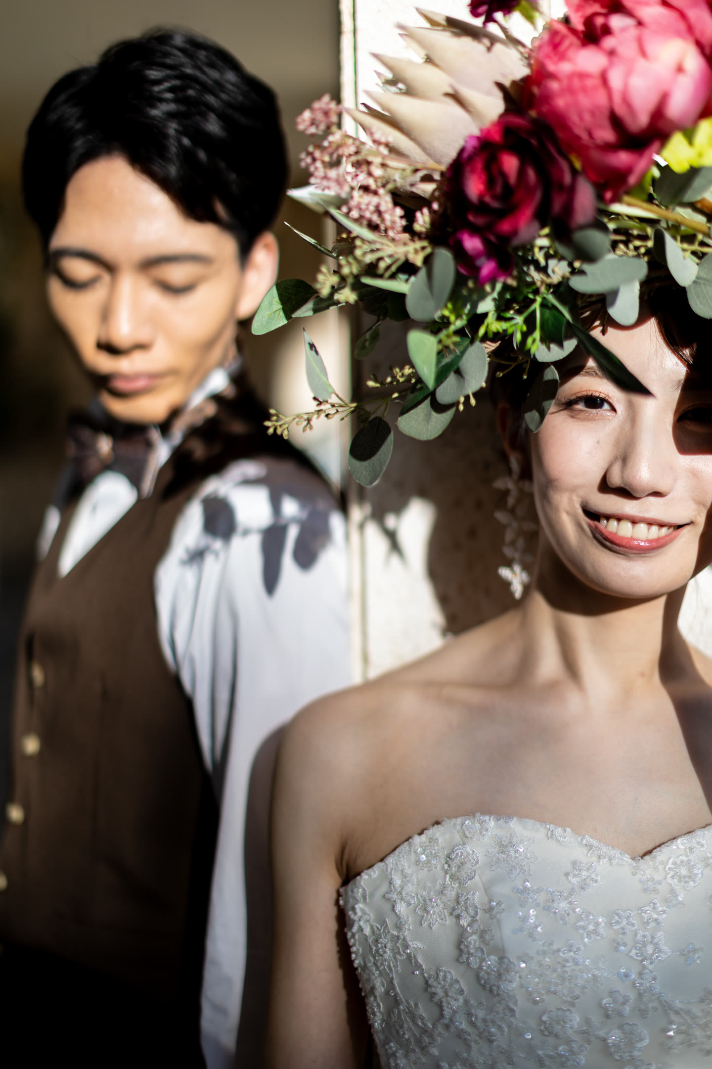 Couple framed by deep red flowers in Okinawa