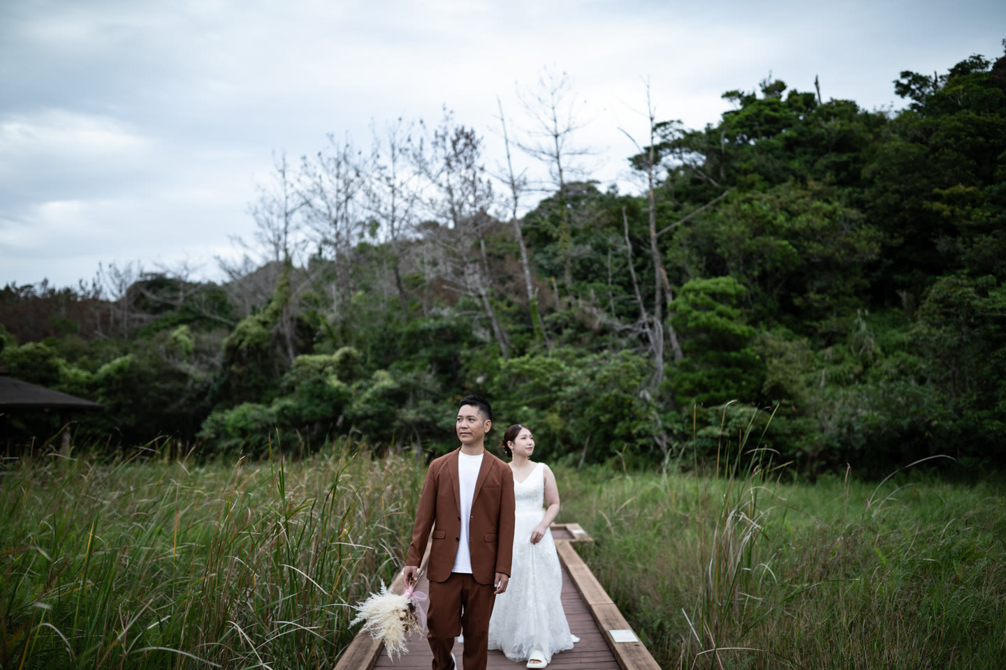 Couple on a boardwalk crossing coastal grassland in Okinawa