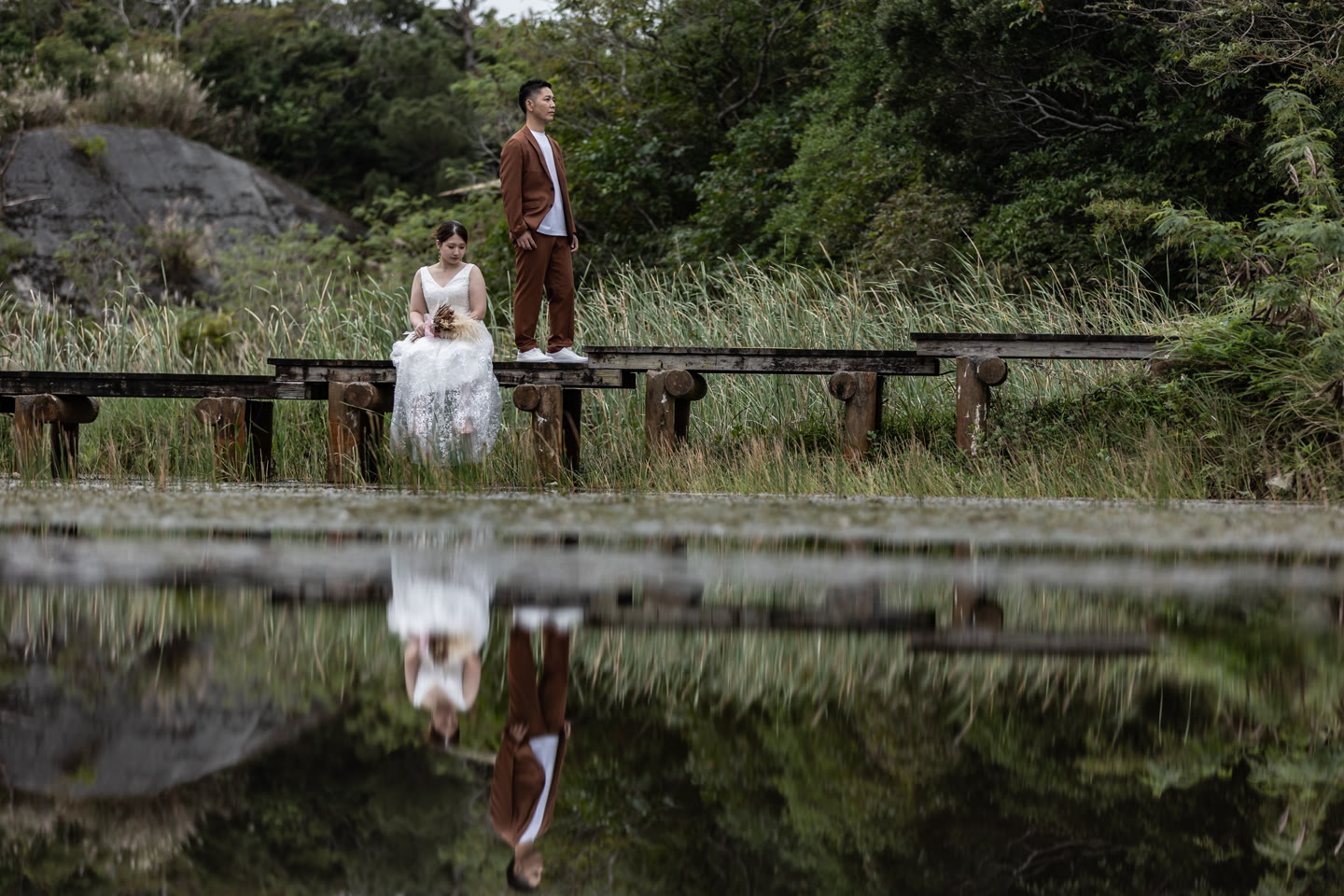 Couple reflected in a mirror-still pond in Okinawa