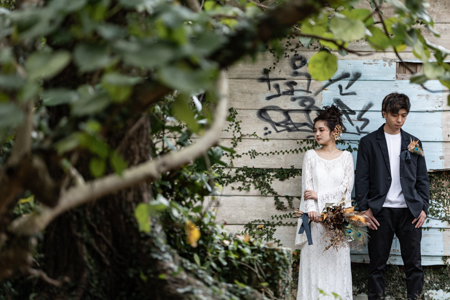 Couple standing in front of a weathered painted wall in Okinawa