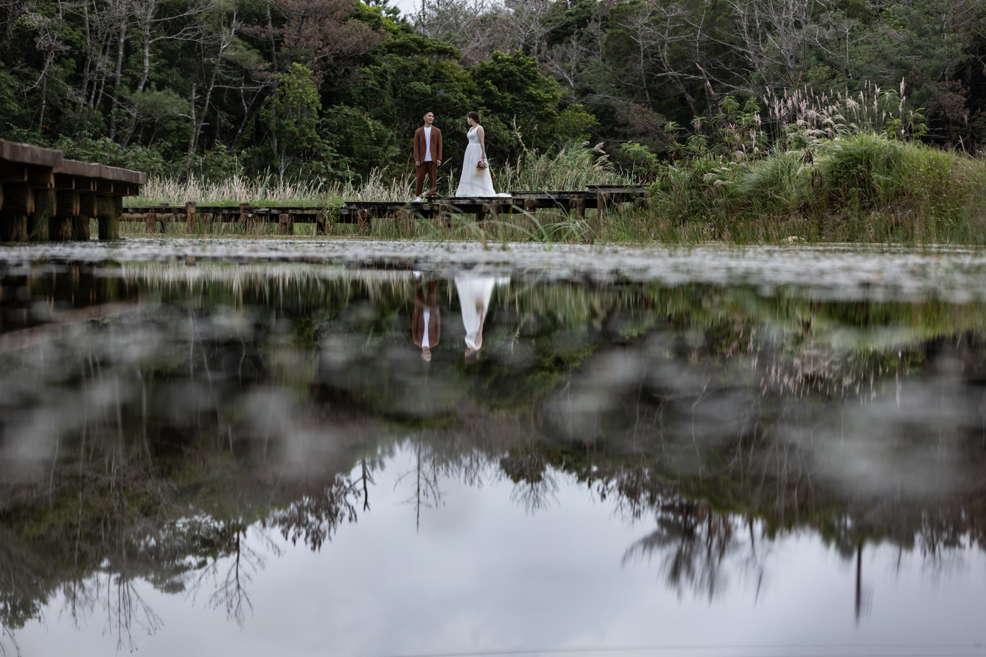 Bride reflected in a still pond during an Okinawa pre-wedding photoshoot