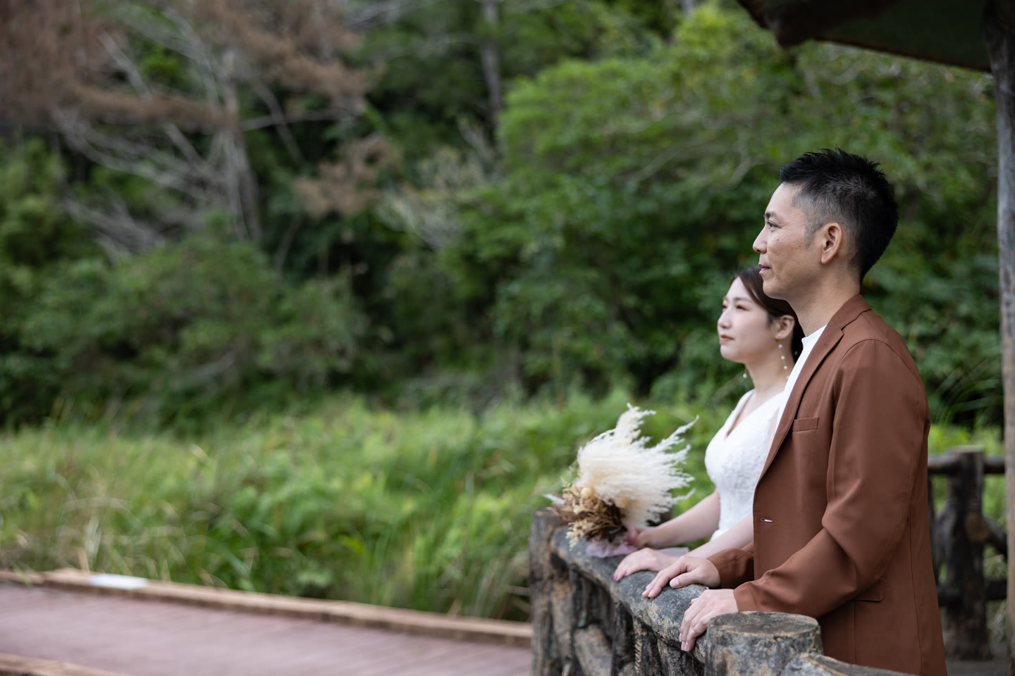 Couple close together beside a coral stone wall in Okinawa