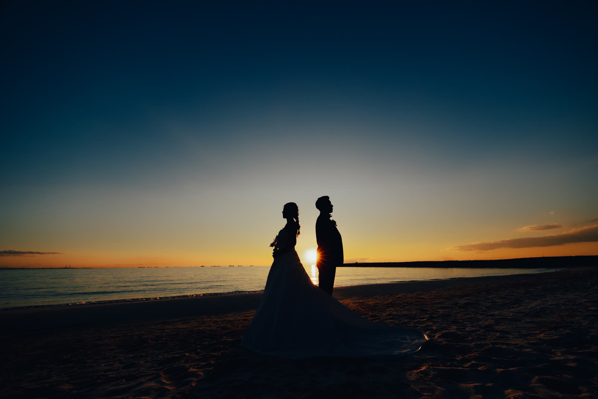 Silhouette of a couple on an Okinawa beach against the sunset during a pre-wedding photoshoot