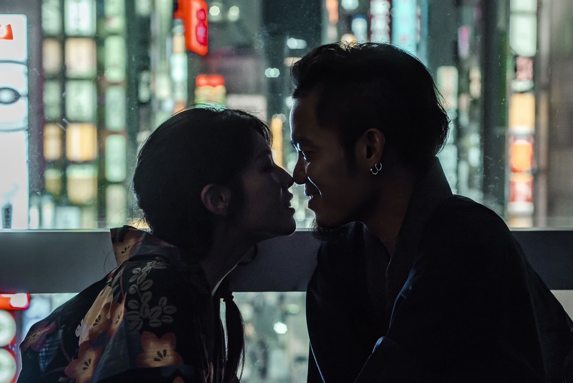 Couple in kimono in silhouette against Tokyo neon at night