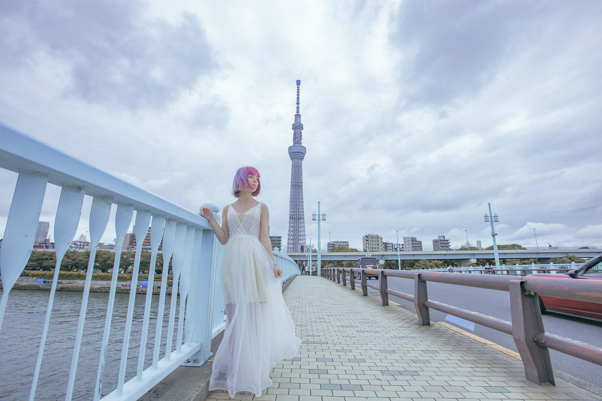 Bride on a riverside bridge with Tokyo Skytree in the distance