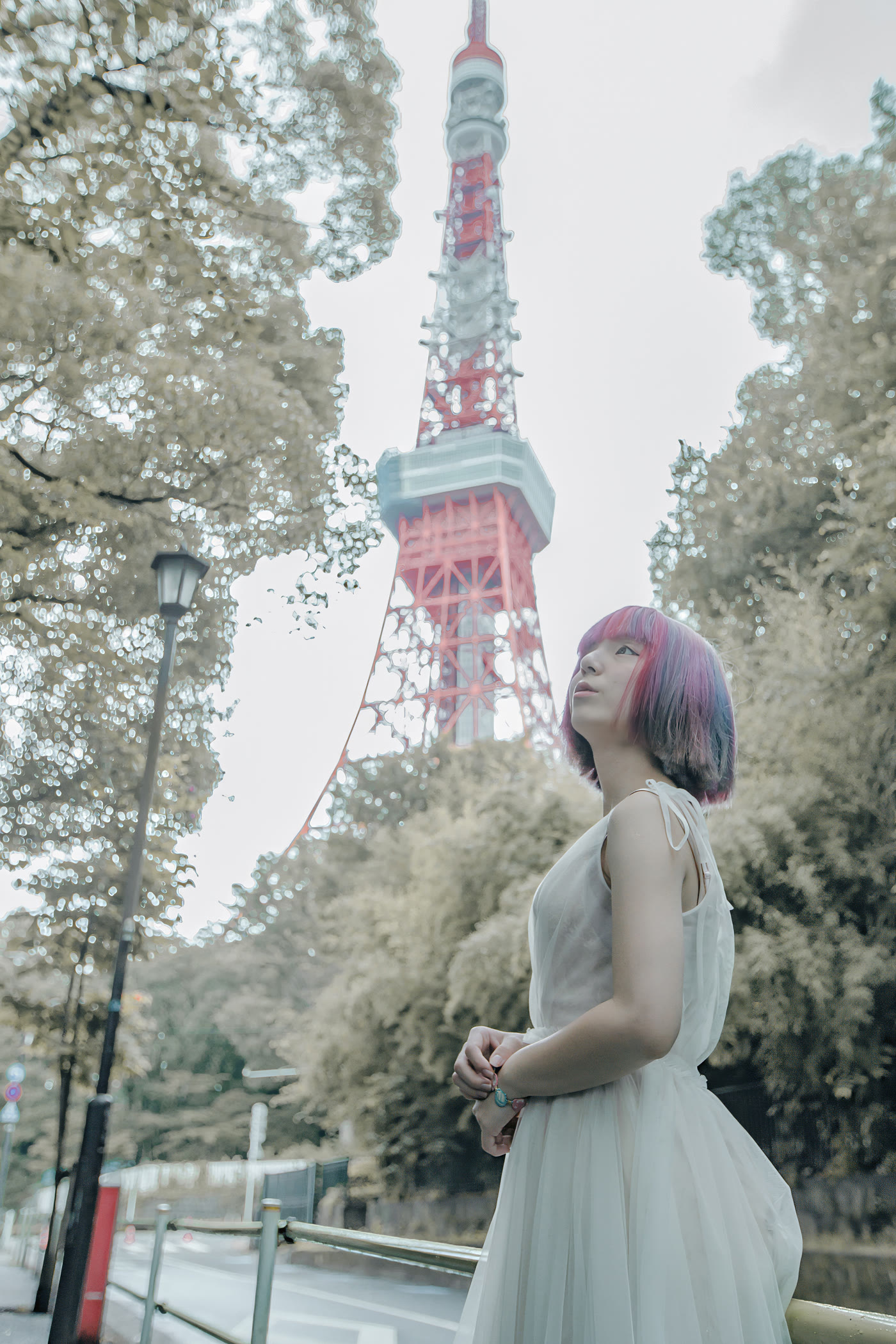 Bride looking up towards Tokyo Tower on a quiet tree-lined street