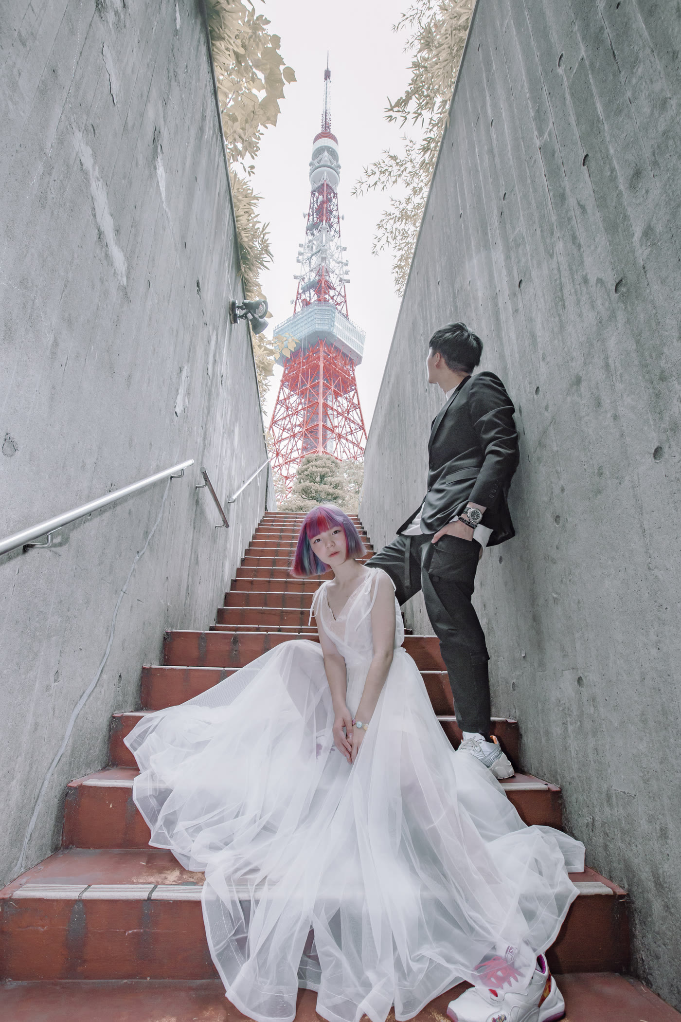 Couple on stone steps leading up towards Tokyo Tower
